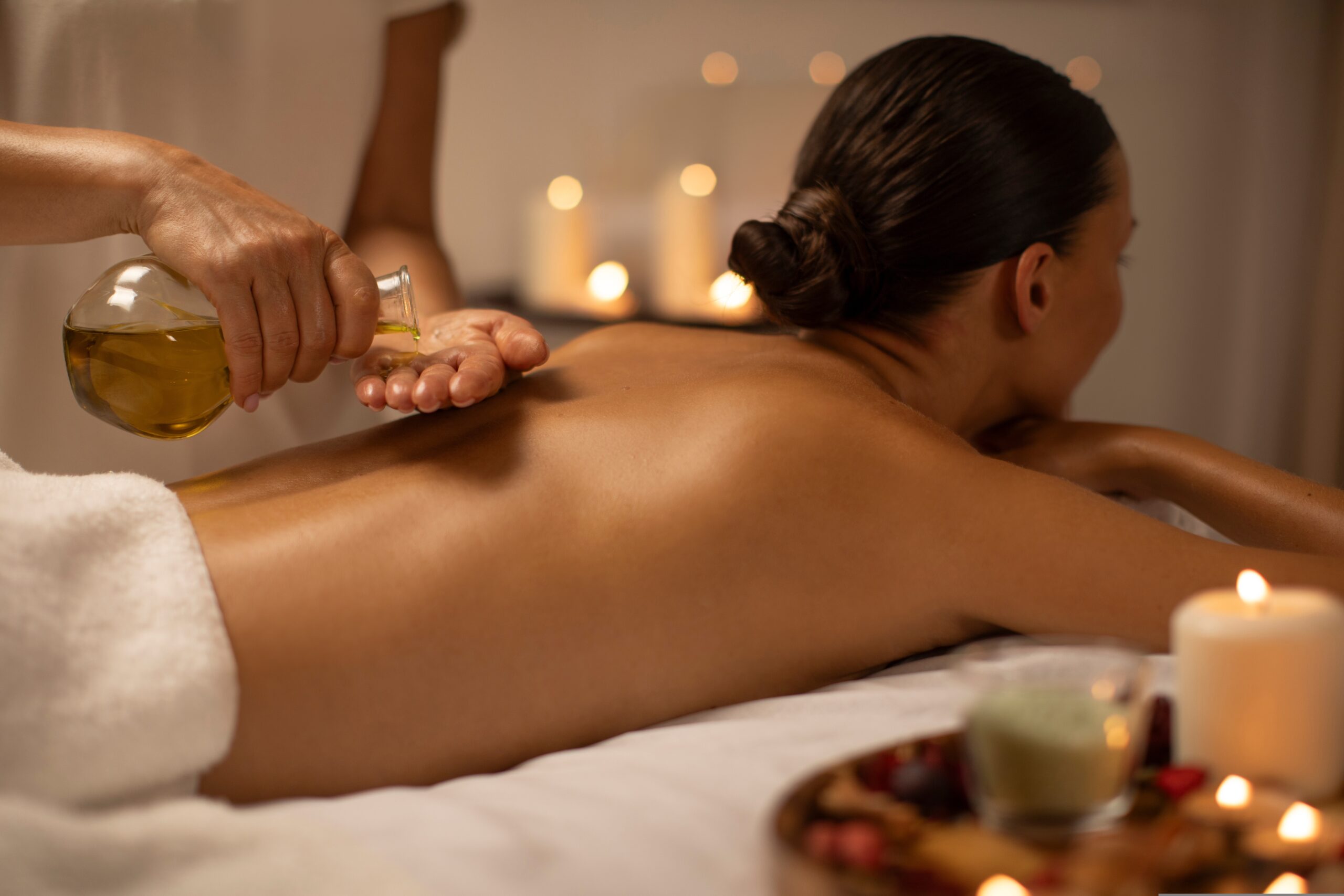 Massage,Therapist,Pouring,Oil,On,Lady,Back,At,Luxury,Spa